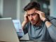 “Person reviewing a low credit score on a digital credit report, symbolizing common credit mistakes.”